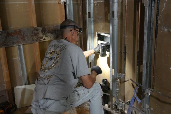 Licensed Las Vegas plumber installing new PVC sewer pipe in trench
