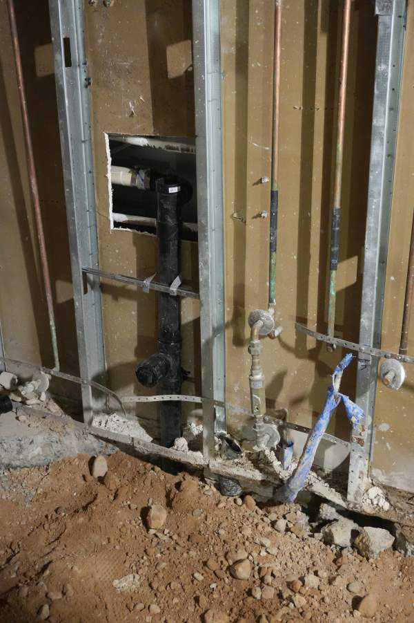 Royalty Plumbing plumber confirming shower drain rough-in location in Las Vegas bathroom before tile
