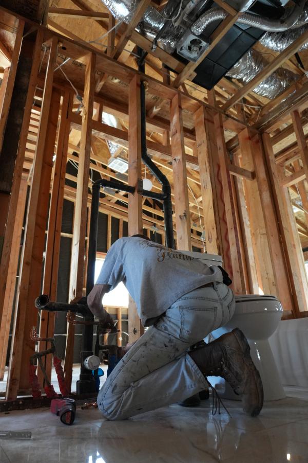 Licensed Las Vegas plumber installing new PVC sewer pipe in trench