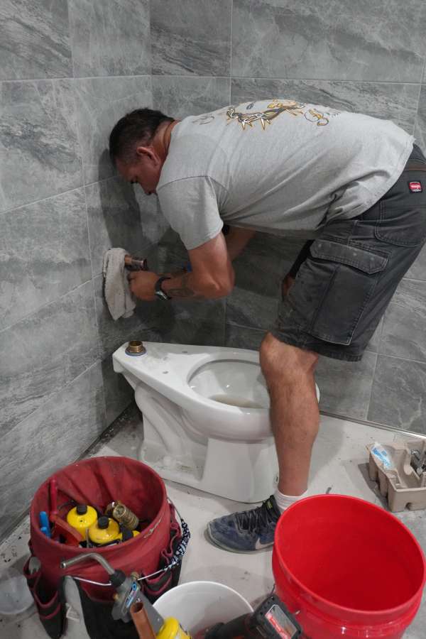 Royalty Plumbing plumber connecting garbage disposal drain connection under Las Vegas kitchen sink
