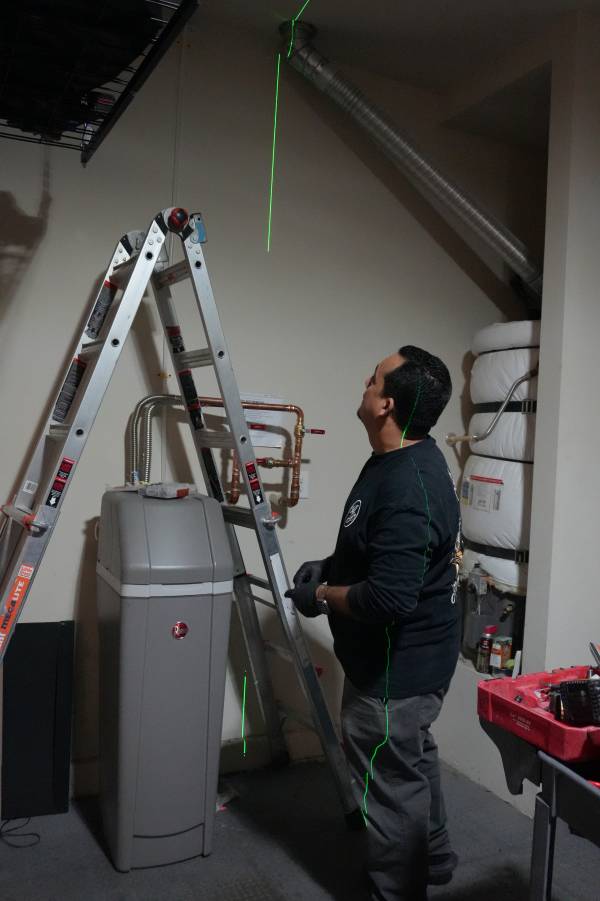Royalty Plumbing plumber inspecting garbage disposal connections under Las Vegas kitchen sink